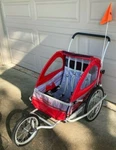 Schwinn Jogging Stroller/ Bicycle Trailer - Red, Two Seats, Buggy, Jogger. Fixed Price $200.00.